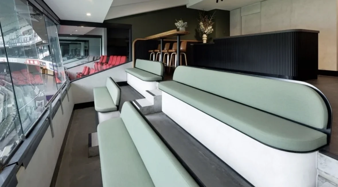 Green banquette seating and a dark counter in a completed project at Marvel Stadium